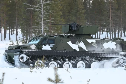 Blindé chenillé Patria TRACKX en camouflage hivernal dans une forêt enneigée